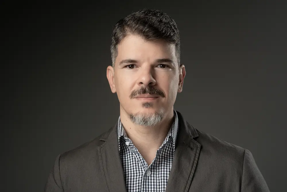 Dr. Shinaider, mastologista, responsável técnico de Mastológica, olhando para a câmera